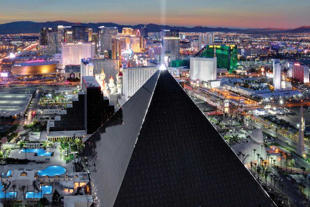 Hôtel Luxor, Las vegas photo du batiment triangle premier plan avec fond ville au coucher du soleil casino vegas règles visiter - Odyssée Américaine
