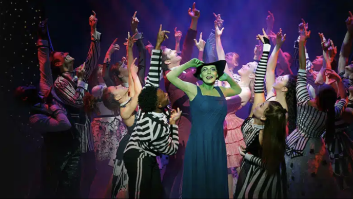 Wicked comédie musicale. acteurs sur la scène. Au moment même ou Wicked sort dans les salles de cinémas Françaises, Wicked, la comédie musicale bat sont plein depuis des années au Gershwin Theater. Plongez vous dans cette étonnante histoire dont les américains raffolent, autant par l’ambiance mystique que sa mise en scène remarquable, au cœur du poumon artistique de Broadway. Odyssée Américaine