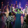 Wicked comédie musicale. acteurs sur la scène. Au moment même ou Wicked sort dans les salles de cinémas Françaises, Wicked, la comédie musicale bat sont plein depuis des années au Gershwin Theater. Plongez vous dans cette étonnante histoire dont les américains raffolent, autant par l’ambiance mystique que sa mise en scène remarquable, au cœur du poumon artistique de Broadway. Odyssée Américaine