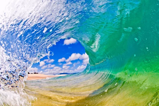 Big Island, photo de vague - c'est la plus grande et la plus jeune des îles hawaïennes ! Ici, la nature se déploie dans toute sa splendeur, mêlant volcans en activité, plages colorées, forêts tropicales, et cieux étoilés parmi les plus beaux du monde. Véritable terre de contrastes, Big Island abrite 9 des 12 zones climatiques mondiales
