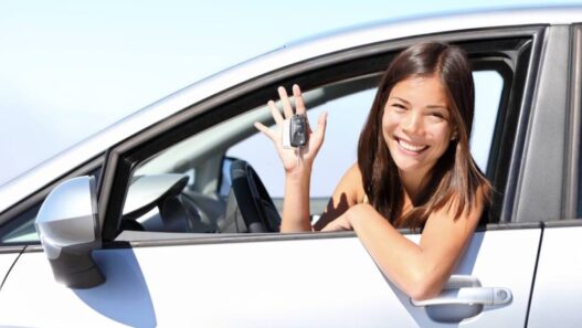 Sourire-location-de-voiture femme en voiture avec des clefs a la main