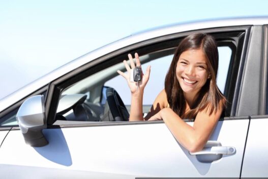 Sourire-location-de-voiture femme en voiture avec des clefs a la main