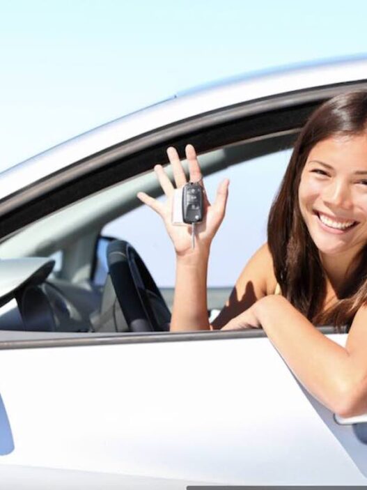 Sourire-location-de-voiture femme en voiture avec des clefs a la main